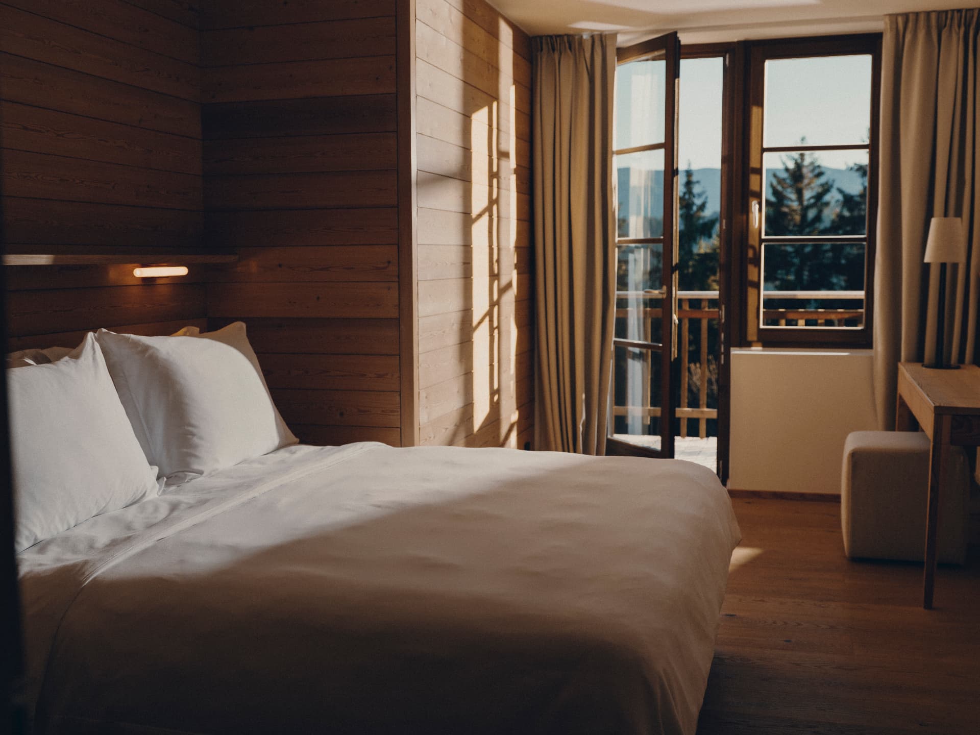 Suite bedroom at FORESTIS with spruce walls and morning light