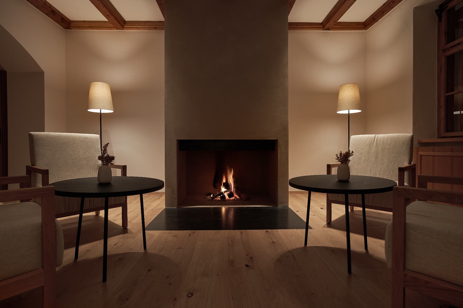 Fireplace and armchairs in the FORESTIS bar lounge at night